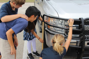 Students measuring a truck headlight.